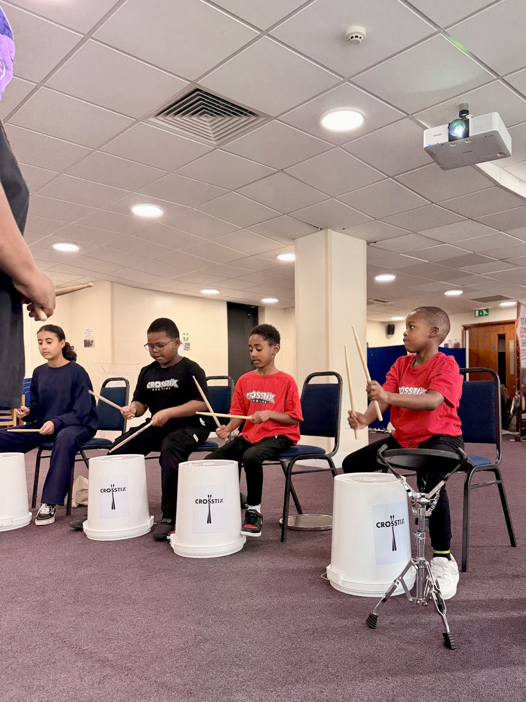 A full academy session, rows of young drummers playing practice drums together