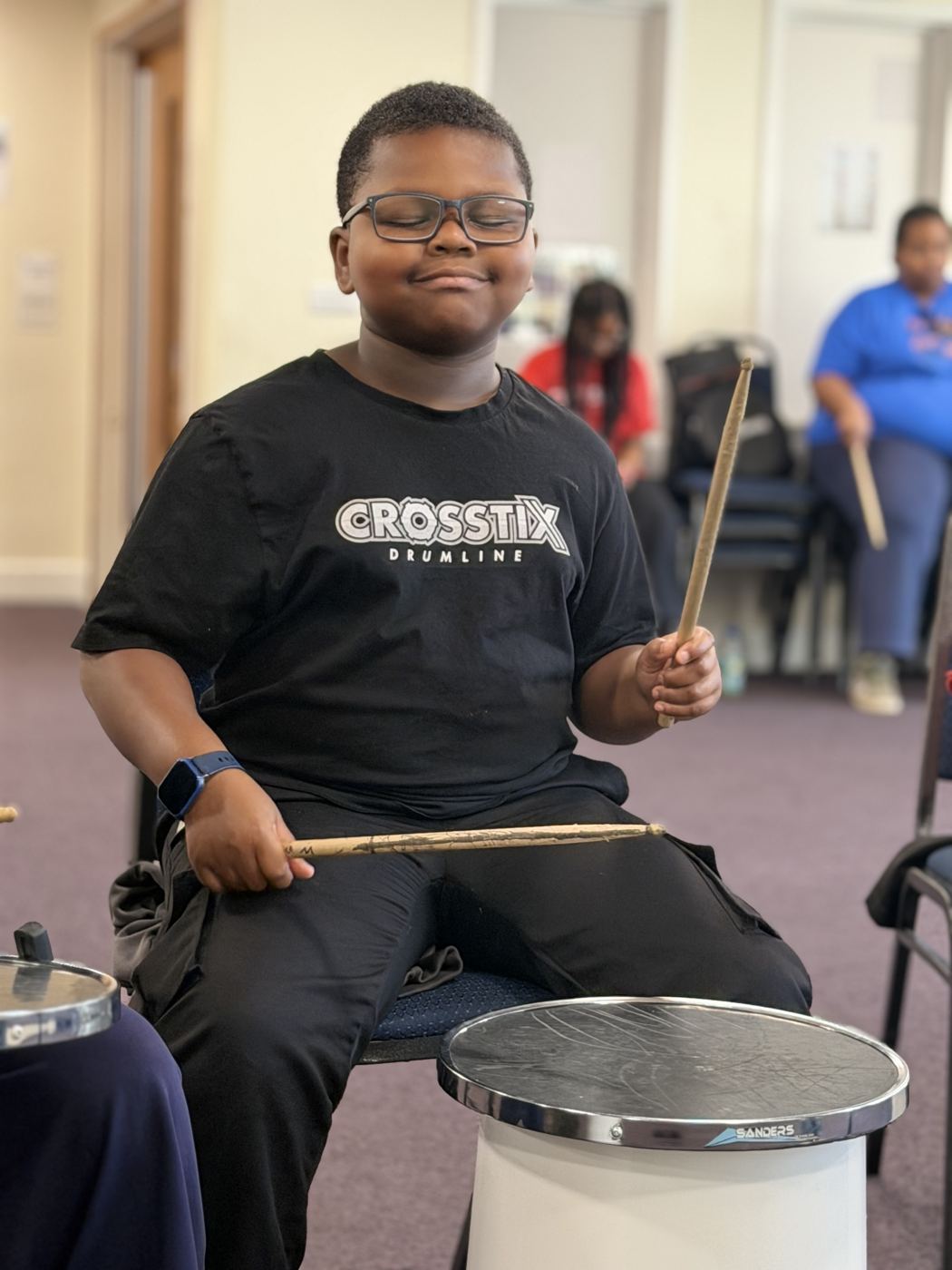 A smiling academy member at his practice drum