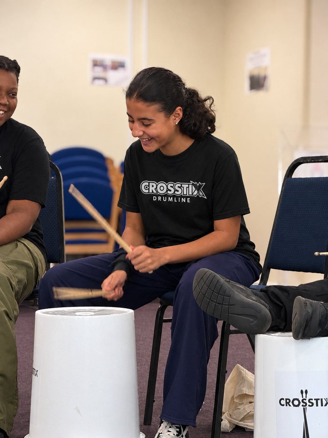 A teenage academy member smiling as she plays