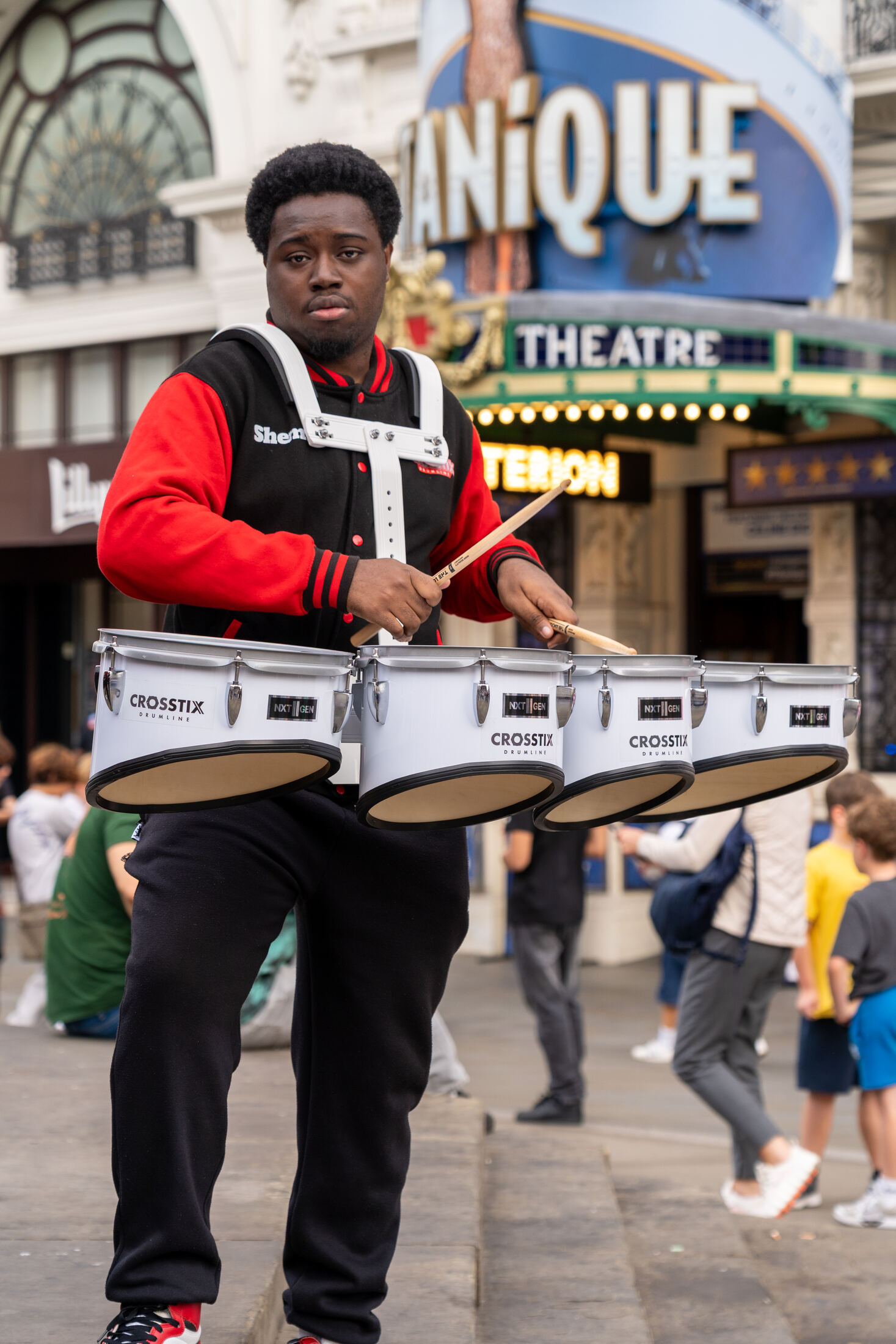 Tenor drummer playing in front of a theatre